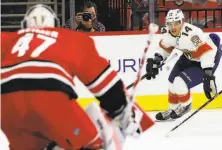  ?? Karl B DeBlaker / Associated Press ?? Florida’s Grigori Denisenko drives the puck toward Carolina goalie James Reimer in the Hurricanes’ win in Raleigh, N.C.