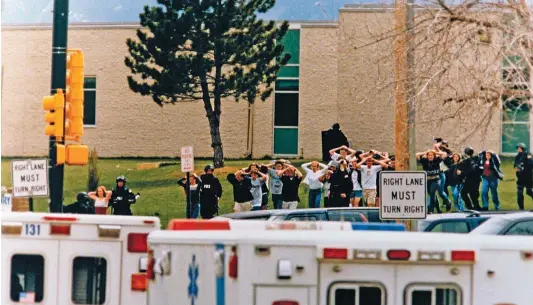  ??  ?? TERROR EN EL INSTITUTO. En la imagen, estudiante­s de la Escuela Secundaria Columbine de Littleton salen aterroriza­dos del centro, escoltados por la policía, tras el tiroteo del 20 de abril de 1999.