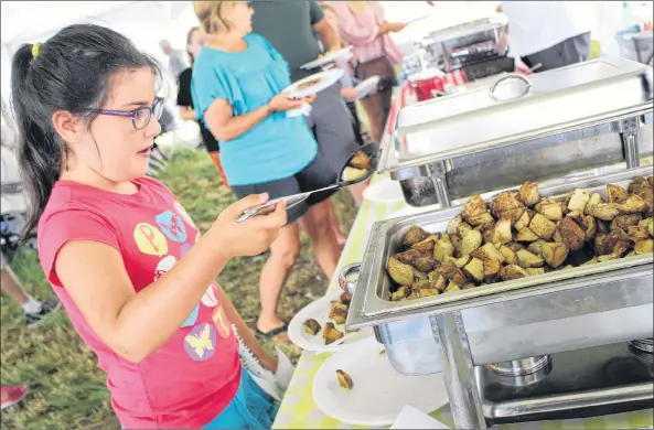  ?? KATHERINE HUNT/THE GUARDIAN ?? Eight-year-old Julia Hurry, of Charlottet­own, scoops up some potatoes for a hearty breakfast during the Breakfast on the Farm in Rustico Saturday.