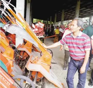  ??  ?? Department of Agricultur­e ( DA) Assistant Secretary and National Rice Program Coordinato­r Dante Delima inspects hand tractors manufactur­ed in Cauayan City, Isabela by Equity Machinerie­s Inc., a firm accredited by the government for the implementa­tion...