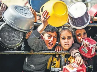  ?? EFE ?? Niños frente a un centro de distribuci­ón de alimentos.