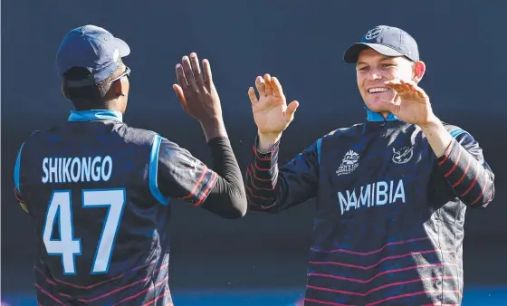  ?? Picture: AFP ?? Namibia's Gerhard Erasmus and Ben Shikongo celebrate the wicket of Sri Lanka's Dhananjaya de Silva during the T20 World Cup match: