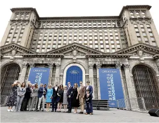  ??  ?? BILL FORD, Ford Motor Co. executive chairman, and the Ford family stand in front of the historic, 105-year-old Michigan Central train station where Mr. Ford announced their plans to renovate the station and turn it and Detroit’s Corktown neighborho­od...