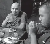  ?? Jonathan Kaiman Los Angeles Times ?? LINUS GUARDIAN ESCANDOR II, left, a 37-yearold freelance photograph­er, has dinner with fellow photojourn­alist Ezra Acayan in Manila.