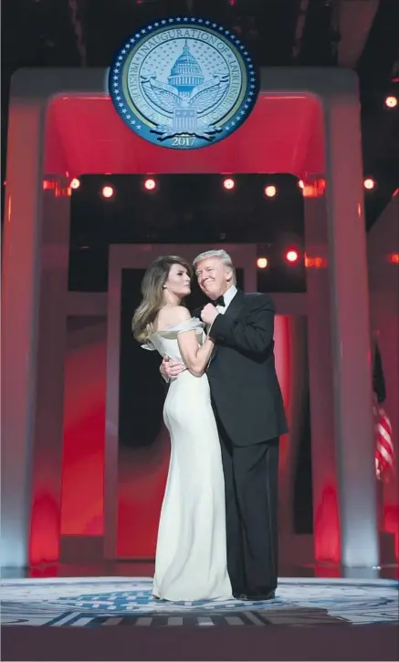  ?? Jim Watson AFP/Getty Images ?? PRESIDENT TRUMP and First Lady Melania Trump dance at the Liberty Ball, with the presidenti­al seal in a place of prominence.