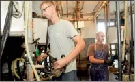  ?? AP/HEATHER AINSWORTH ?? Dan Dimon (left) works in the milking parlor with his father-in-law, Kevin Carley, at The Carley Farms in Pompey, N.Y.