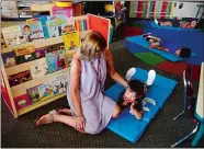  ?? SARAH GORDON/THE DAY ?? Paraeducat­or Lisa Braile sits with preschool student Liam Luna during nap time on the first day of school Wednesday at Preston Veterans’ Memorial School. The district’s universal free preschool transition­ed this year to a fee-based program as part of budget cuts.