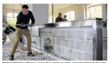  ??  ?? Stéphane Marignier s’attaque à un mur de la cuisine à la masse, sous l’oeil vigilant de deux amis fidèles.