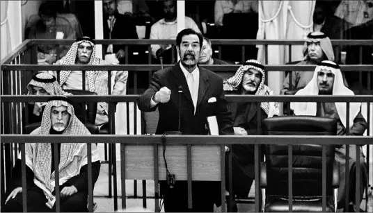  ?? BEN CURTIS/ AP ?? Defiant former Iraqi leader Saddam Hussein is surrounded by his co-defendants as he addresses the court in Baghdad yesterday. His trial has been adjourned until Monday.