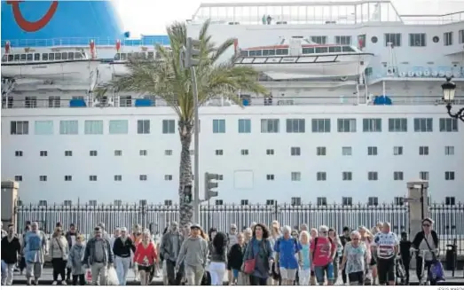  ?? JESÚS MARÍN ?? Imagen de archivo de turistas y ciudadanos de Cádiz cruzando Canalejas con un crucero de fondo tras la verja del Muelle.