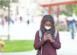  ?? PATRICK BREEN/ THE REPUBLIC ?? Daba Yague wears a mask as she walks between classes Monday after a coronaviru­s case was reported on ASU’s Tempe campus.