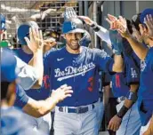  ?? ?? IT’S HIGH-FIVES all around for Chris Taylor after he scored on a two-run double by Mookie Betts.