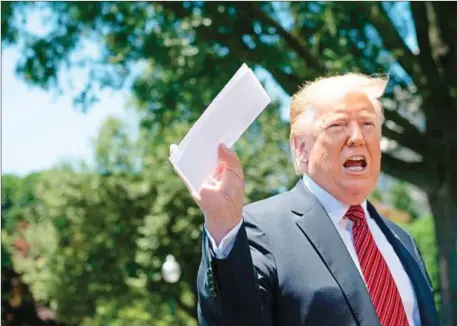  ?? JIM WATSON/AFP ?? US President Donald Trump holds piece of paper saying it is his deal with Mexico as he speaks with reporters at the White House in Washington, DC on Tuesday.