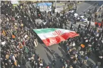  ?? NIMA NAJAFZADEH/TASNIM NEWS AGENCY VIA AP ?? A demonstrat­or waves a huge Iranian flag during a pro-government rally in the northeaste­rn city of Mashhad, Iran, on Jan. 4.