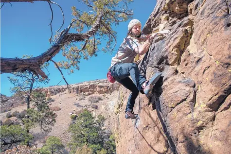  ?? EDDIE MOORE/JOURNAL ?? Pete Yeo, from Albuquerqu­e, climbs a boulder in Mills Canyon northwest of Roy last week.