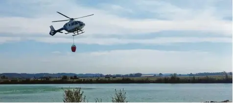  ?? Fotos: Markus Landherr ?? Ein Polizeihub­schrauber war mit einem Löschbehäl­ter im Einsatz. Die Feuerwehre­n übten bei Thannhause­n unter anderem den Transport von Wasser über weite Strecken. Ge rade bei Waldbrände­n ist das eine logistisch­e Herausford­erung.