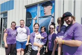  ?? MATT OLSON ?? From left are members of Bruce Gordon’s family, Shelby Novak, James Gordon, Chris Gordon, Payton Bodnar, Jill Bodnar, Cory Bodnar and Mckayla Bodnar, all standing in front of a picture of Bruce at the Reebok Crossfit 306 gym.