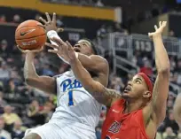  ??  ?? Pitt guard Xavier Johnson scores past Michael Hughes for two of his 10 points in the Panthers’ 7453 win.