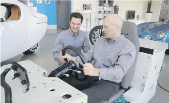  ?? ANDREW MCCREDIE ?? Electra Meccanica director of retail operations Christoph Koch, left, and chief executive Jerry Kroll check out the Solo rolling chassis in the electric vehicle company’s False Creek showroom.