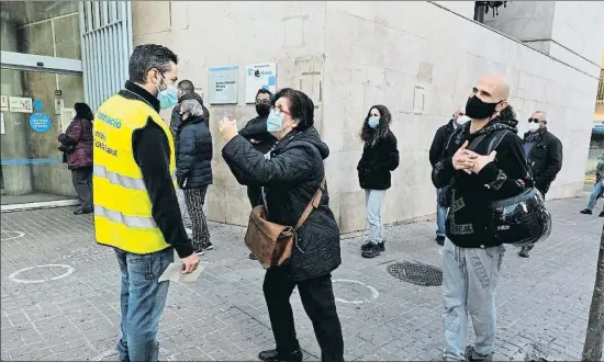  ?? MERCÈ GILI ?? Raúl, el pasado viernes, atiende a una usuaria en la cola formada frente a la puerta del CAP Llefià de Badalona, cuyos accesos controla