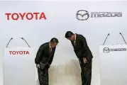  ?? [AP PHOTO] ?? Toyota Motor Corp. President Akio Toyoda, left, and Mazda Motor Corp. President Masamichi Kogai, right, bow to each other before a news conference in Tokyo Friday. Japanese automakers Toyota Motor Corp. and Mazda Motor Corp. said Friday they plan to...
