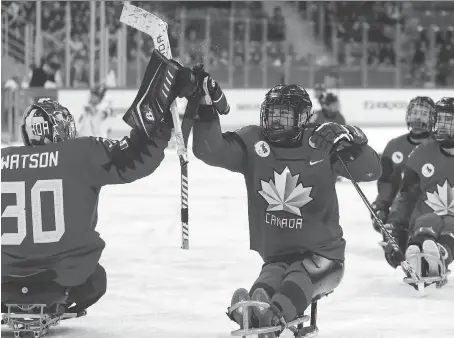  ?? NG HAN GUAN/THE CANADIAN PRESS/THE ASSOCIATED PRESS ?? Canada’s Billy Bridges, centre, celebrates a goal during a 7-0 semifinal win on Thursday.