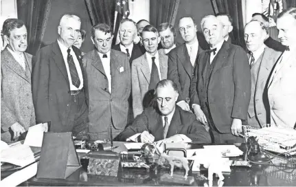  ?? SUBMITTED ?? President Franklin D. Roosevelt signs the TVA Act on May 18, 1933. The president is surrounded by members of Congress from the TVA region, and at his left shoulder is Sen. George Norris of Nebraska, after whom Norris Dam is named.
