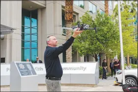  ?? ?? Metro Detective Gregory Stevens reaches out to grab the drone after a demonstrat­ion f light.