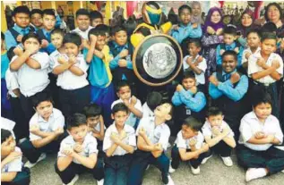  ??  ?? MACC mascot Commission­er DZ (centre) with pupils of SK Hashim Awang in Kepala Batas at the launch of 'Sahabat Cilik' programme aimed at educating primary schoolchil­dren on the fight against corruption.