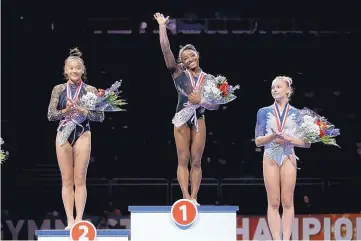  ?? CHARLIE RIEDEL/ASSOCIATED PRESS ?? All-around winner Simone Biles, center, stands on the podium with second-place finisher Sunisa Lee, left, and third-place finisher Grace McCallum. Biles won her sixth national championsh­ip.