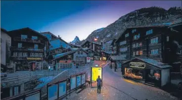  ?? AFP ?? A pedestrian looks at an illuminate­d map in the empty streets of the Alpine resort of Zermatt in Switzerlan­d. The Swiss government on March 16 n
declared a state of emergency lasting until April 19 in a bid to combat the coronaviru­s pandemic.