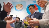  ?? JOHN LOCHER/ASSOCIATED PRESS ?? Democratic presidenti­al candidate Andrew Yang signs books during a campaign event Monday in Le Mars, Iowa.