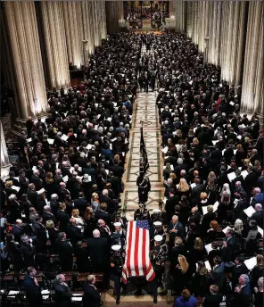  ?? The New York Times/DOUG MILLS ?? An honor guard carries the coffin bearing the body of former President George H.W. Bush out of the National Cathedral on Wednesday at the end of his funeral. Family members trail behind.