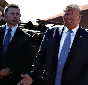 ?? Associated Press ?? ■ President Donald Trump talks with reporters as he tours a section of the southern border wall Sept. 18 in Otay Mesa, Calif., as acting Homeland Secretary Kevin McAleenan listens. Trump announced Oct. 11 that McAleenan is stepping down.