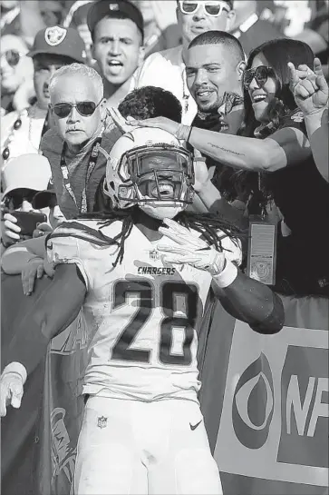  ?? D. Ross Cameron Associated Press ?? CHARGERS FANS celebrate with Melvin Gordon after his second-quarter touchdown against Oakland.