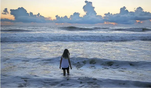  ?? — AFP ?? Charlotte Miller visits the beach ahead of the arrival of Hurricane Florence on Wednesday in Nags Head, North Carolina. Hurricane Florence is expected on Friday possibly as a category 4 storm along the Virginia, North Carolina and South Carolina coastline.