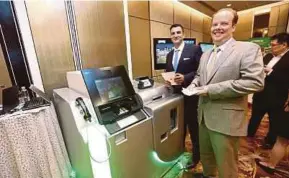  ?? PIC BY MUHD ZAABA ZAKERIA ?? NCR Financial Services vice-president for Asia Pacific Matthew Heap (right) showcasing an NCR financial product in Kuala Lumpur recently.