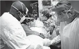  ?? AARON LAVINSKY/STAR TRIBUNE 2020 ?? Critical care nurses and respirator­y therapists work on a COVID-19 patient in Robbinsdal­e, Minnesota. The Midwest is seeing a surge in new cases.
