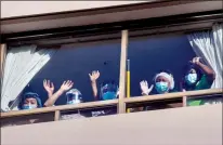  ?? CP PHOTO FRANK GUNN ?? Nurses and PSWs at Sienna Senior Living St. George Care Community in Toronto wave from the windows as a support rally takes place in front of the building on January 7.