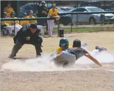  ?? ?? Michael Cruz slides into home plate to tag out a West Las Vegas Don on Friday (March 25).