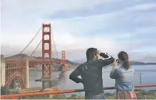  ?? Lea Suzuki / The Chronicle ?? Tran Nguyen ( left) and Meriam Rumai view the Golden Gate Bridge on Friday. Cooler weather arrived for the weekend.
