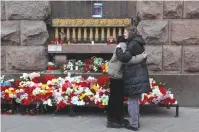  ?? (Anton Vaganov/Reuters) ?? WOMEN HUG next to a makeshift memorial for the victims of Moscow’s Crocus City Hall shooting attack, in St. Petersburg yesterday.