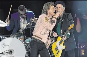  ?? Chris Pizzello The Associated Press ?? Mick Jagger, center, and Keith Richards of the Rolling Stones share vocals during the band’s performanc­e Oct. 14, 2021, at Sofi Stadium in Inglewood, Calif. At left is touring drummer Steve Jordan.