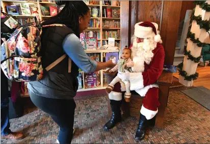  ?? CHRIS RILEY — TIMES-HERALD ?? Seven-month-old Sutton Ward sits on Santa’s lap during a visit to the Alibi Bookshop in downtown Vallejo on the day after Thanksgivi­ng in Vallejo on Friday.