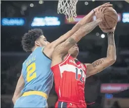  ?? Kyusung Gong Associated Press ?? LAKERS ROOKIE Lonzo Ball blocks a shot by Washington Wizards forward Kelly Oubre Jr. during the first half at Staples Center.