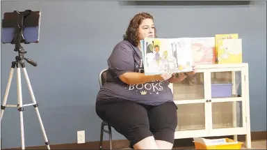 ?? LYNN KUTTER ENTERPRISE-LEADER ?? Amanda Thulin, children’s librarian for Prairie Grove Public Library, reads a book about kindergart­en during Storytime last week. In addition to in-person Storytime, Thulin also is on Facebook Live at the same time.