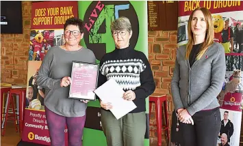  ?? ?? Warragul Crochet Club’s May Cornwall and Julie Beasley at the presentati­on with assistant branch manager Katy Slater.