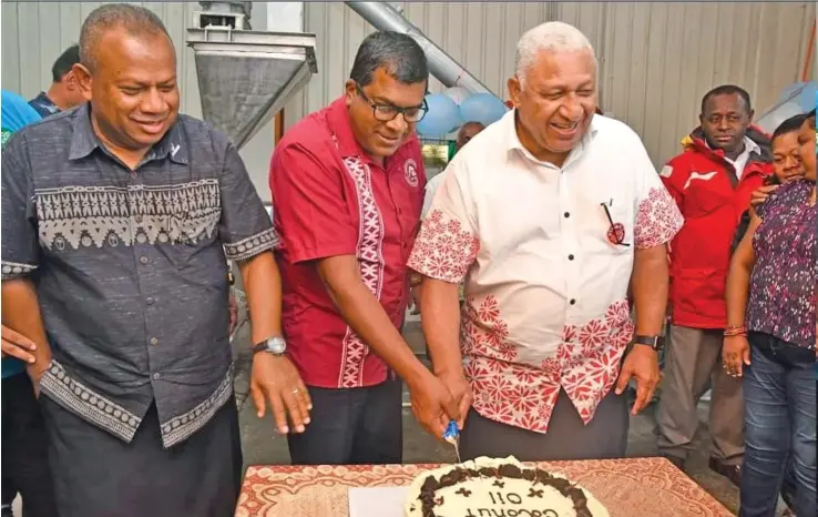  ??  ?? Minister for Rural and Maritime Developmen­t and Disaster Management Inia Seruiratu (left) joins Minister for Agricultur­e Mahendra Reddy and Prime Minister Voreqe Bainimaram­a to cut a celebratio­n cake for the recent launching of the Fiji Coconut Millers Pte Limited’s edible coconut oil in Savusavu.