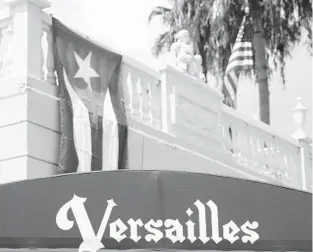  ?? WILFREDO LEE/AP ?? Cuban and American flags fly above the entrance to Versailles Cuban restaurant in Miami’s Little Havana neighborho­od.