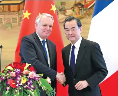  ?? FENG YONGBIN / CHINA DAILY ?? Foreign Minister Wang Yi shakes hands with French Foreign Minister Jean-Marc Ayrault after a joint news conference at the Ministry of Foreign Affairs in Beijing on Friday.